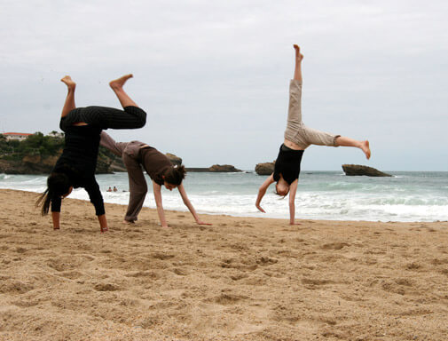 three of us doing cartwheels on a French beach