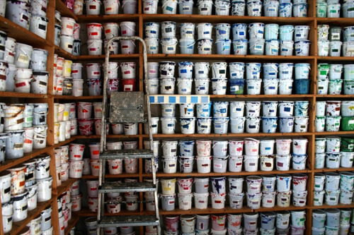 shelves full of buckets of paint organized neatly