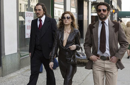 Christian Bale, Amy Adams, and Bradley Cooper walking down the street