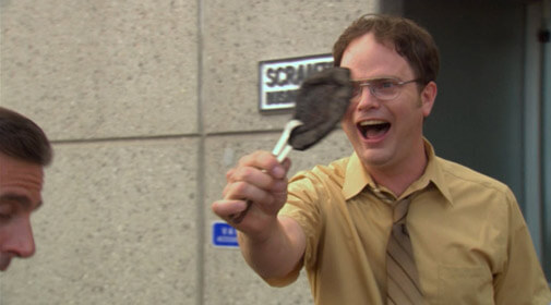 Dwight holding up a burnt pita with tongs