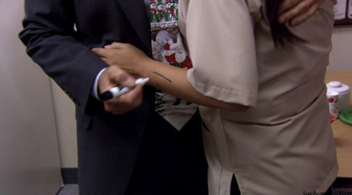 Michael marking a woman’s arm with a dry erase marker