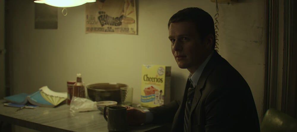 Holden sits at a kitchen table next to a box of Cheerios