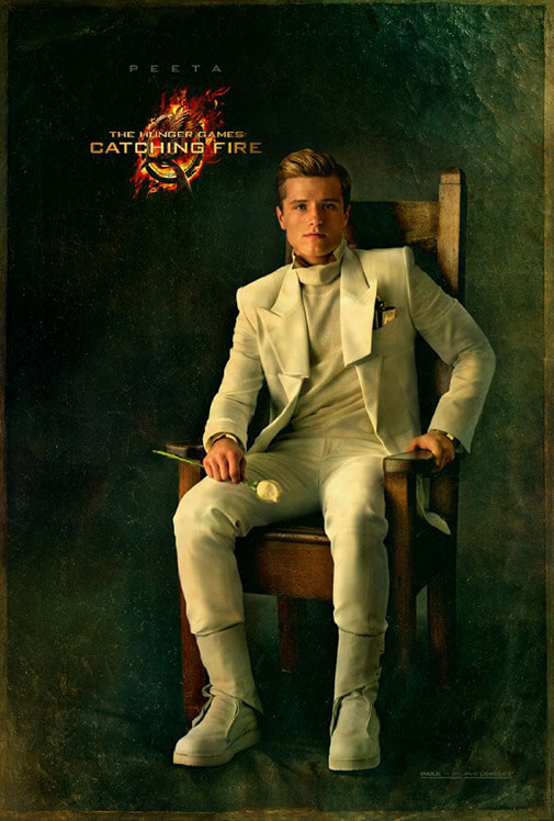 Peeta in a white suit and holding a white rose