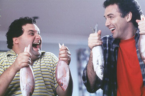 Artie Lange and Norm MacDonald each holding two fish and laughing