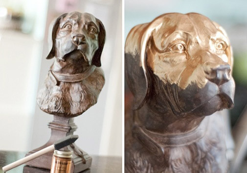 a metal dog bust sculpture in process of being gold leafed