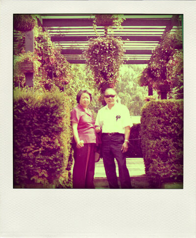 Polaroid photo of my grandparents in a garden