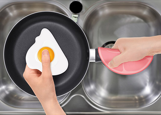 a hand uses a sliced ham to hold a pan and a fried egg to clean it