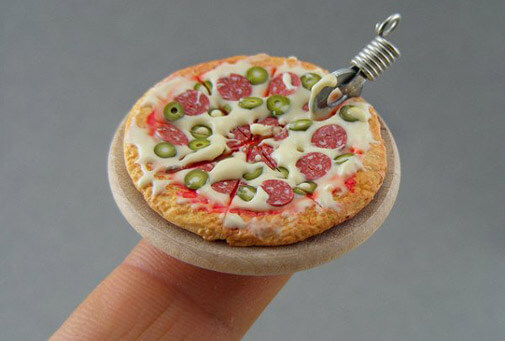 a tiny pizze on a person’s fingertip