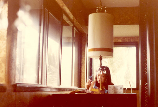 vintage photograph of my mom smoking at a desk behind a cool light fixture