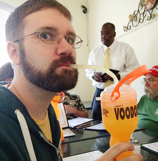 Clay sipping orange drink from a big plastic to-go bottle with bendy straw