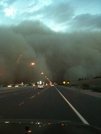 a big wall of dust approaches the freeway