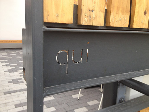 entrance to the restaurant with “qui” cut out of steel