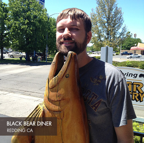 Clay with a wooden fish sculpture at Black Bear Diner in Redding