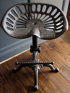 metal stool that looks like a tractor seat