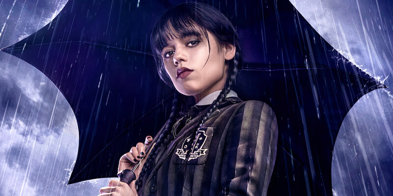 Wednesday Addams holding an umbrella in the rain