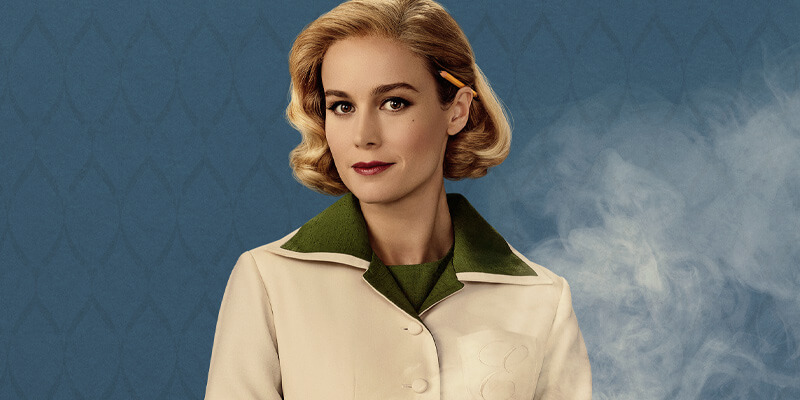 Brie Larson in 1950s hairstyle and dress with a pencil behind her ear