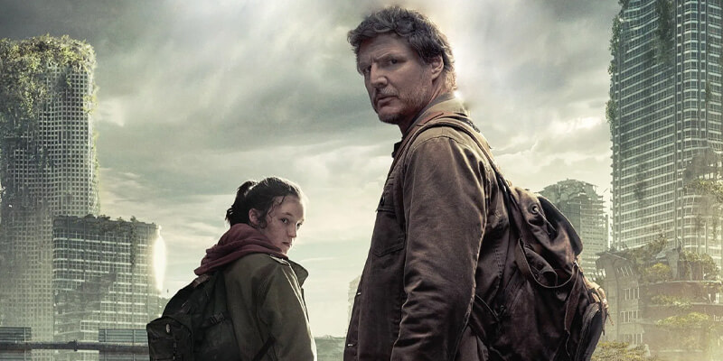 Pedro Pascal and Bella Ramsey look back at the camera before a post-apocalyptic, overgrown city